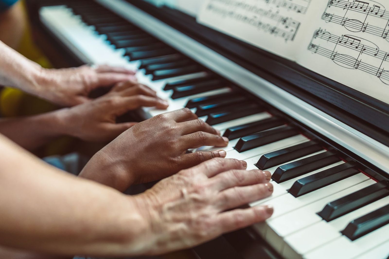 Hände am Klavier mit Noten, Unterrichtssituation