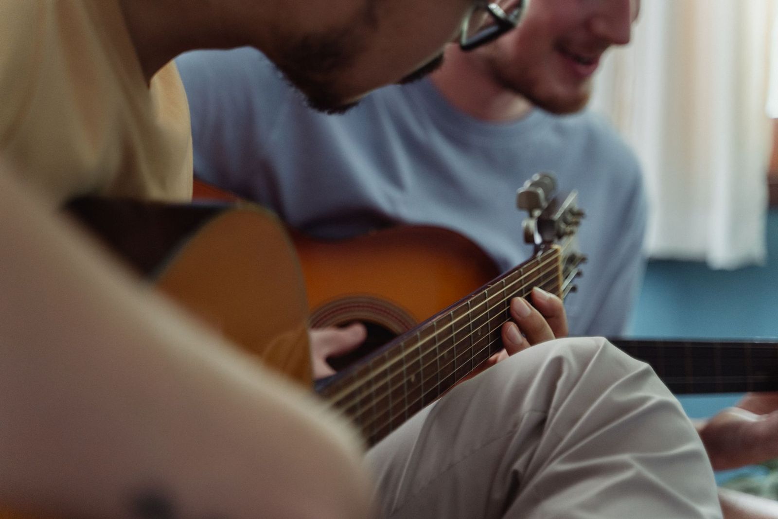 Zwei Männer spielen gemeinsam Akustikgitarre